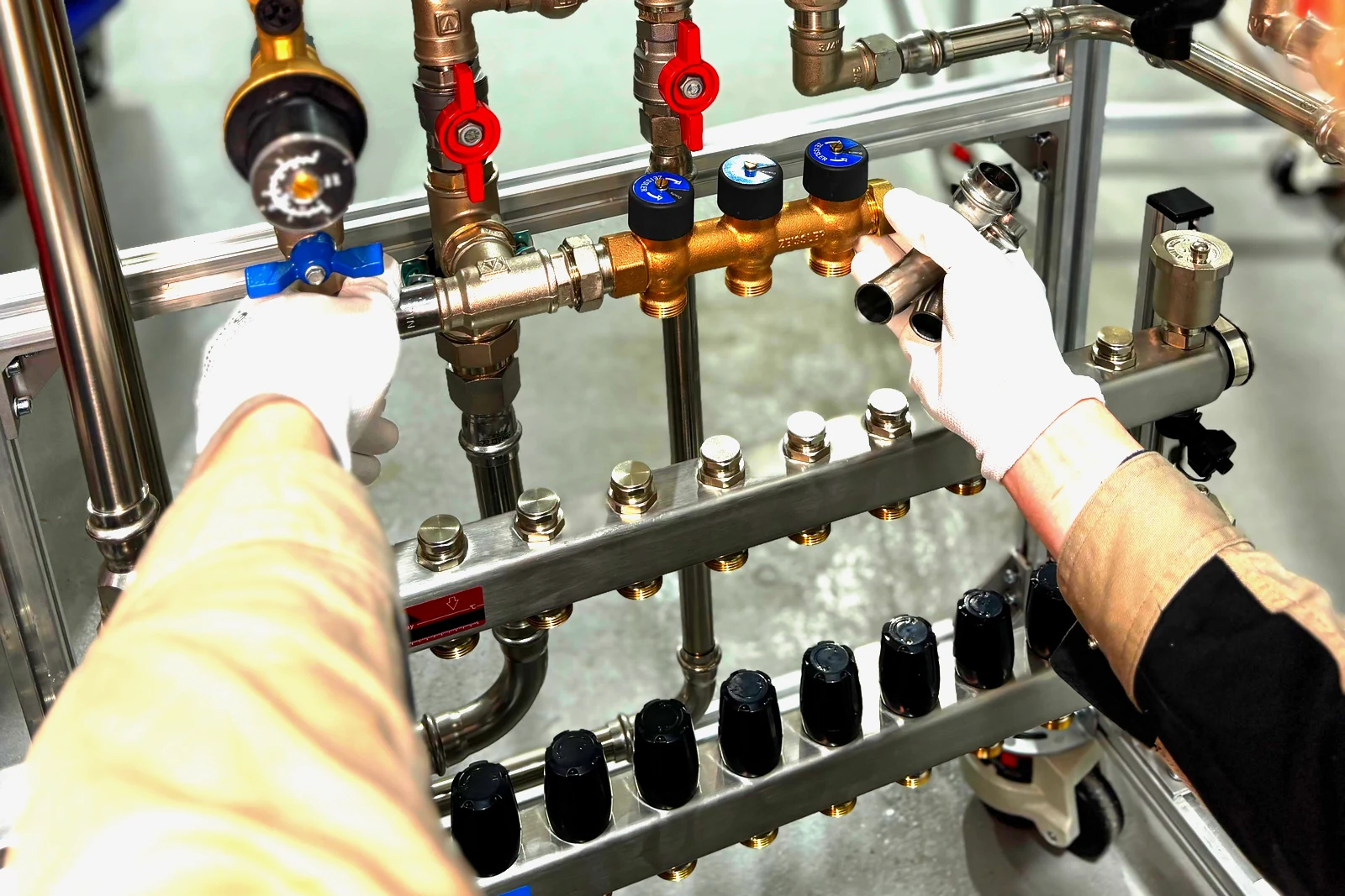 A gas fitter working on a manifold of valves and pipework