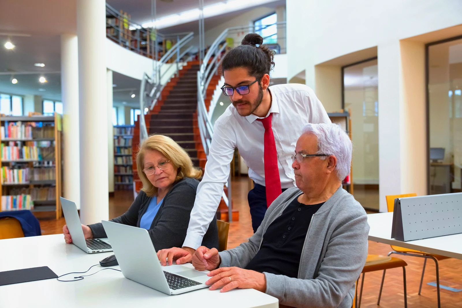 Council library staff helping residents at a bank of laptops