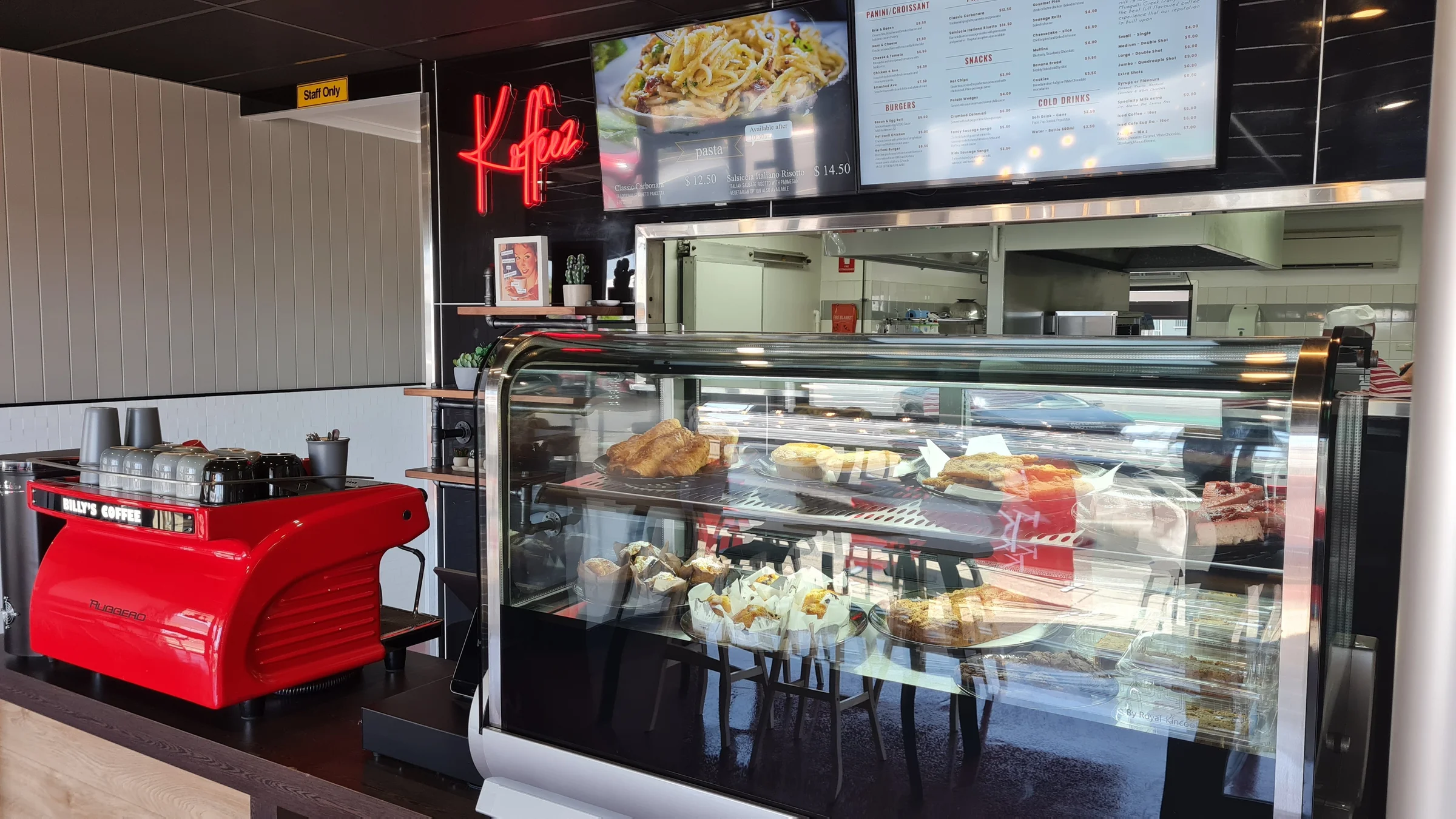 Koffeez service counter with neon branding, red espresso machine, and fresh food display in Cairns