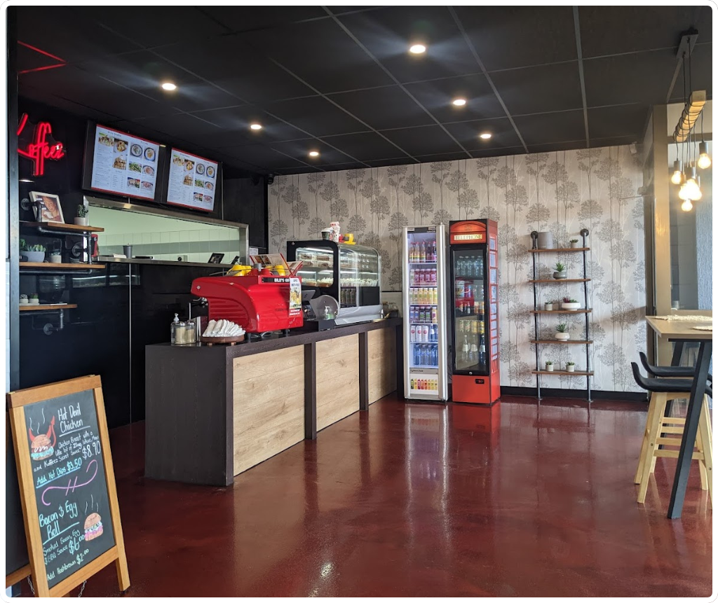 Koffeez café interior with service counter, red espresso machine, and refrigerated drinks display in Cairns