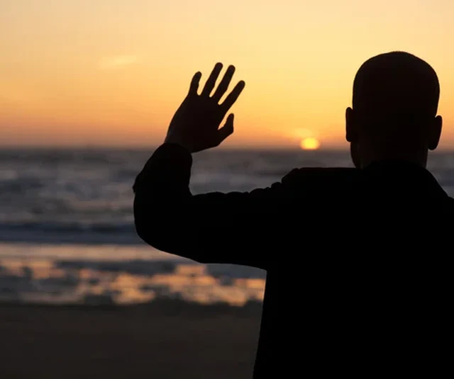 Silhouette of a person waving goodbye at sunset, reflecting on why staff leave