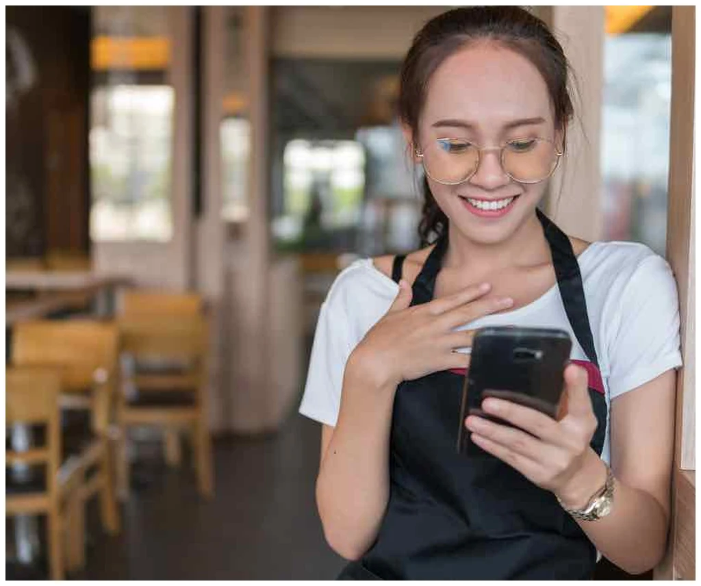 Cafe employee checking goals and reviews on the RosterElf app
