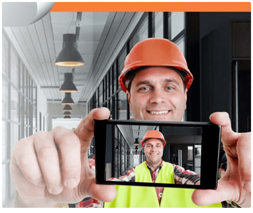 Construction worker taking selfie photo for clock-in verification on smartphone
