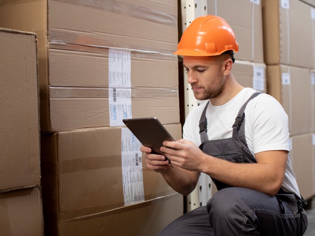 Warehouse worker checking a shift task list on a tablet